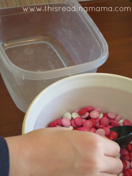 scooping m & m candy into empty container | This Reading Mama