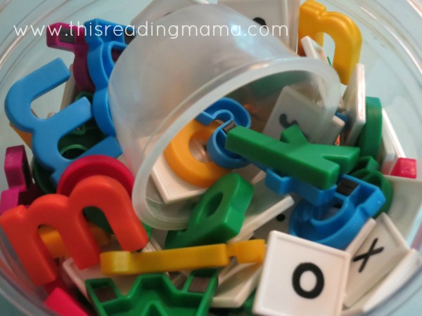letter tiles and magnetic letters dumped in a container together