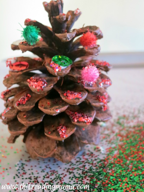 sprinkling glitter on pine cone Christmas trees