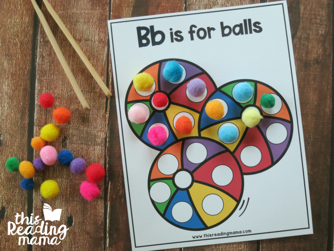 covering alphabet dot pages with pom-poms